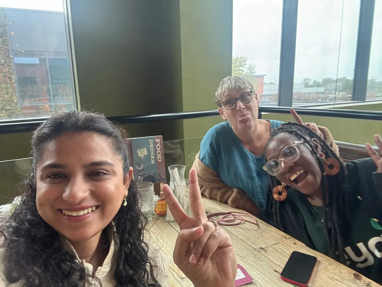 Three Neya members smiling together around a pub table